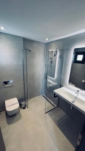 uma casa de banho com um chuveiro, um WC e um lavatório. em Sunset Hotel em Ouranoupoli