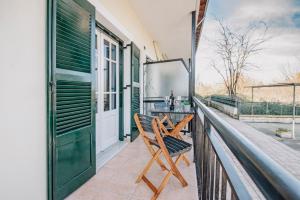 a porch with a table and a chair on a balcony at Ionian Luxury Apartments in Perama