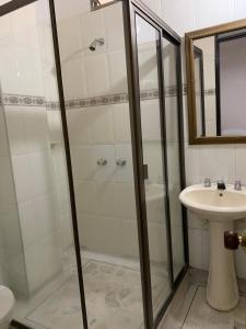 y baño con ducha y lavamanos. en HOTEL EJECUTIVO, en Pitalito
