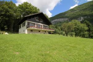 a house on top of a grassy hill at Comfortable Chalet - View of Lake Aiguebelette in Nances