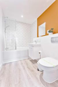 a bathroom with a toilet and a tub and a sink at Contemporary 2 Bed Apartment Nightingale Quarter Derby in Derby