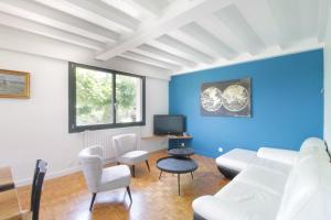 una sala de estar con paredes azules y muebles blancos. en Beautiful villa on the slopes of Lake Aiguebelette! en Saint-Alban-de-Montbel