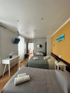 ペニシェにあるResidência Avizのベッド2台とデスクが備わるホテルルームです。