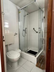 ペニシェにあるResidência Avizのバスルーム(トイレ、ガラス張りのシャワー付)