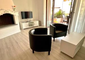 uma sala de estar com duas cadeiras e uma televisão em Ascona: ORTO DEGLI ANGIOLI em Ascona