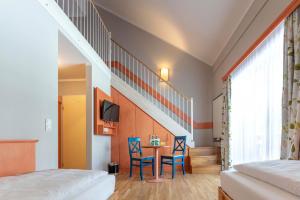 a bedroom with a staircase and a table and chairs at JUFA Hotel Hochrindl in Hochrindl