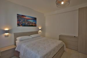 1 dormitorio con 1 cama con una pintura en la pared en NONNA GENEROSA APARTMENTS, en Castellammare di Stabia