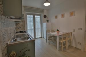 cocina con fregadero y mesa con sillas en NONNA GENEROSA APARTMENTS, en Castellammare di Stabia