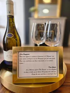 a bottle of wine and two glasses on a table at L'Elegant - Cosy, Design et Charme en HyperCentre in Dijon