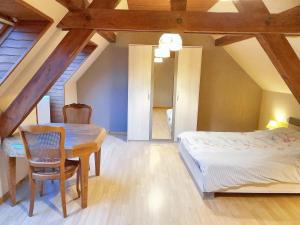 um quarto com uma cama, uma mesa e uma cadeira em Maison de 3 chambres avec terrasse amenagee et wifi a Ingersheim em Ingersheim