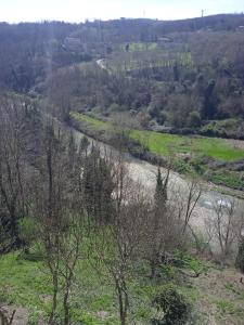 a river in the middle of a field with trees at Casa di Paola a Tufo in Santa Paolina