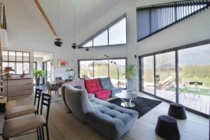 ein Wohnzimmer mit einem Sofa und einem Tisch in der Unterkunft Magnificent villa with heated swimming pool and air conditioning! in Viviers-du-Lac