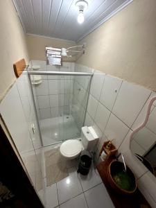 a bathroom with a toilet and a glass shower at Casa di Vó in Mucugê