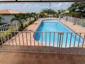 a swimming pool with a fence around it at FINCA LA ALDEA Cabañas campestres in La Tortuga