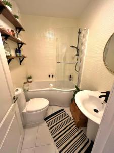 uma casa de banho com um WC, uma banheira e um lavatório. em The Terrace Garden Flat em Bournemouth