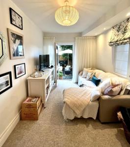 um quarto com uma cama, uma secretária e uma televisão em The Terrace Garden Flat em Bournemouth