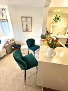 uma sala de estar com duas cadeiras verdes e uma mesa em The Terrace Garden Flat em Bournemouth