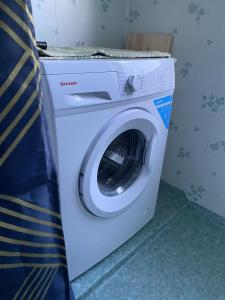 a white washing machine sitting in a room at Genuine 100 year old countryside cottage in Rimbo