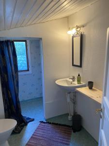 a bathroom with a sink and a toilet and a window at Genuine 100 year old countryside cottage in Rimbo