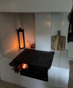 a room with a stove in the middle of a room at Genuine 100 year old countryside cottage in Rimbo