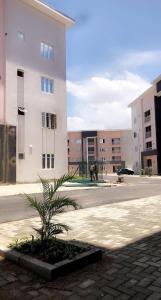 a building with a palm tree in front of a street at Marathona Shortlets Abuja in Abuja