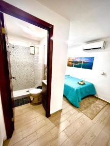 a room with a bathroom with a bed and a toilet at Mayara Hostal in El Zonte