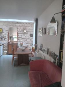 salon ze stołem i kamienną ścianą w obiekcie Paris, central et calme w Paryżu