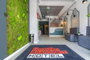 a lobby with a green wall and a carpet at URBAN BUDGET HOTEL in Timişoara