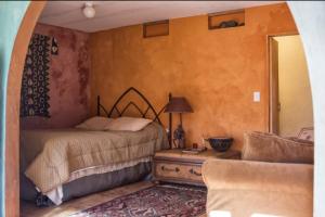 a bedroom with a bed and a table with a lamp at Hacienda Hideaway + Mountain View, Creek & Trails in Topanga