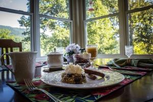 une table avec une plaque de nourriture sur une table dans l'établissement Andon-Reid Inn Bed & Breakfast, à Waynesville