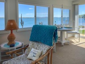 een woonkamer met een tafel en een stoel met een blauwe deken bij Acadia Bay Cottages in Surry