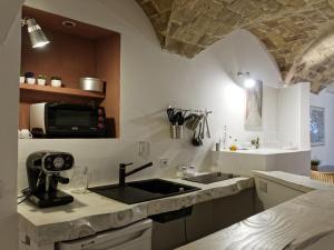 una cucina con lavandino e forno a microonde di Le Stalle del Seminario a Tarquinia