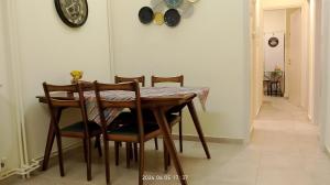 a dining room table with chairs and a clock on the wall at Anna's Flat No2- 2 bedroom apartment in Volos