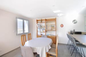 uma cozinha com mesa e cadeiras num quarto em Pretty new and comfortable house between towns and lakes em Voglans