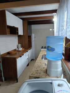 a kitchen with a large blue bucket on the counter at Ôxe Uai Hostel in Arraial d'Ajuda