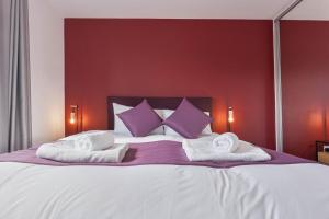 - une chambre dotée d'un grand lit avec des oreillers violets et blancs dans l'établissement Stunning 1 Bed Apartment Nightingale Quarter Derby, à Derby