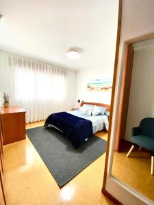 1 dormitorio con cama y espejo grande en Apartamento Rivela, en Burela de Cabo