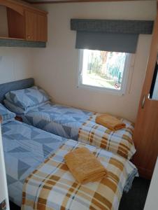 アベルゲレにあるModern 2 Bedroom Static Caravan - Lyons Kingsley Holiday Park - Pensarn, Abergele - Pet Friendlyの窓付きの小さな部屋のベッド2台