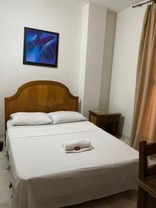 Un dormitorio con una cama con una toalla. en HOTEL EJECUTIVO, en Pitalito