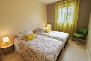 1 dormitorio con 2 camas y silla verde en Comfortable T3 at the foot of the Castle of Chambéry! en Chambéry