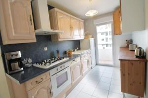 a kitchen with white cabinets and a stove top oven at Comfortable T3 at the foot of the Castle of Chambéry! in Chambéry