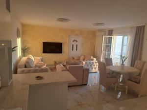 a living room with couches and a table and a tv at DINA LUX Apartman in Jagodina