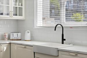 a white kitchen with a sink and a window at Portia-Close to City Ctre Beach in Geelong +13 photos