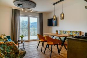Haus Alpenblick في سانت ولفغانغ: مطبخ وغرفة معيشة مع طاولة وكراسي