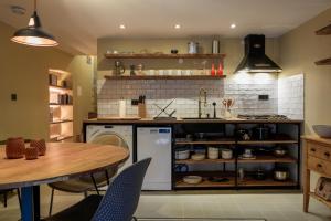 a kitchen with a table and a sink and a counter at Cosy Getaway in Gostinjac