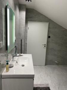 ein Badezimmer mit einem Waschbecken und einer weißen Tür in der Unterkunft Bane Apartments 95qm - Messewohnung, Ferienwohnung,Monteurwohnung in Hannover