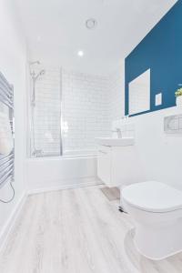 a bathroom with a toilet and a tub and a sink at Lovely 2 Bed Apartment Nightingale Quarter Derby in Derby