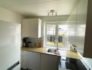 eine Küche mit einem Waschbecken und einem Fenster in der Unterkunft Byhus centralt på Læsø in Vesterø Havn