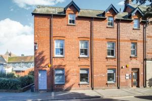 an old red brick building on a street at Nomi Homes * Budleigh Salterton*Beach* Sleeps 4 in Budleigh Salterton