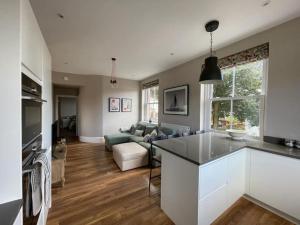 a kitchen and living room with a couch and a table at Nomi Homes * Budleigh Salterton*Beach* Sleeps 4 in Budleigh Salterton